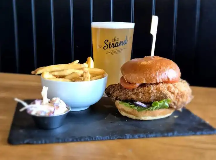 A picture of a chicken burger, fries and a pint at The Strand